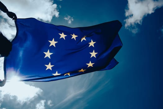 Waving European Union flag on blue sky.