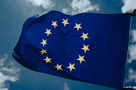 Waving European Union flag on blue sky.