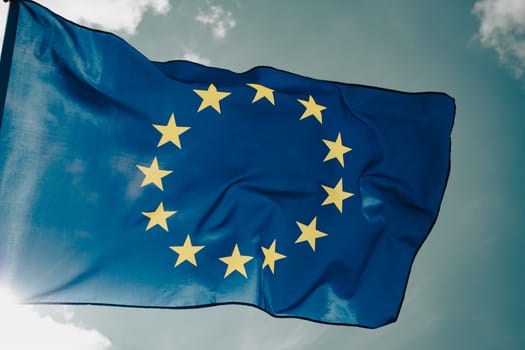 Waving European Union flag on blue sky.