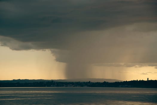 Dramatic sunset with stormy sky and rain over the Constance lake, Germany