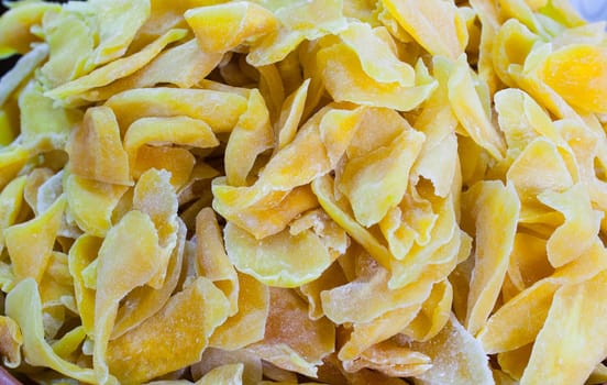 Bowl with dried mango fruit. Slices displayed at street market stall