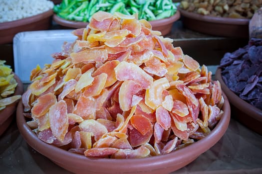 Bowl with dried papaya fruit. Slices displayed at street market stall