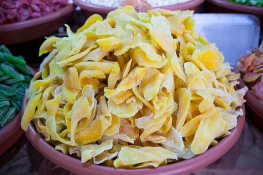 Bowl with dried mango fruit. Slices displayed at street market stall