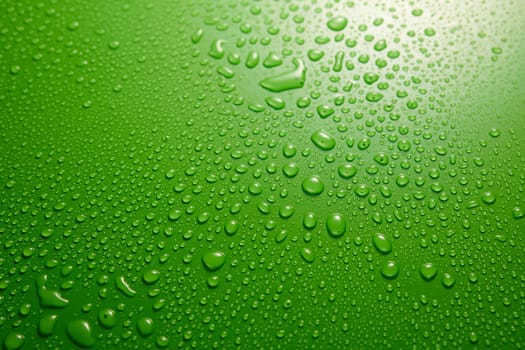 Full frame of clean green background covered with various drops of water flowing down in light room during rainy weather