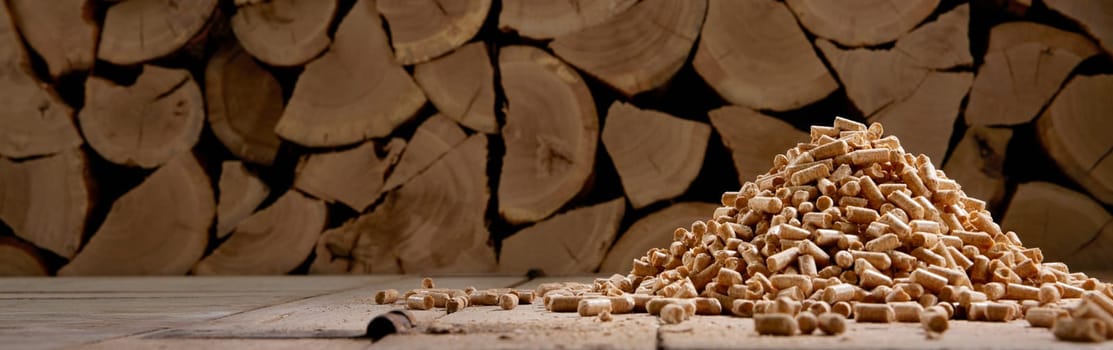 Ground level of chopped woodpile stacked in rural house with heap of compressed fuel pellets in daylight