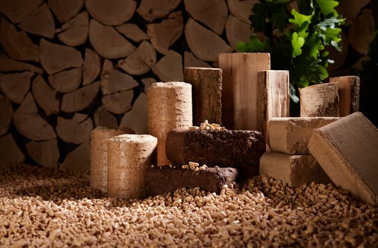 Various compressed solid biomass briquettes placed on pile of pellets against stack of firewood in daylight