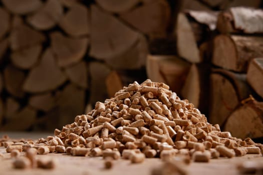 Ground level of stack of small cylindrical fuel pellets scattered on floor near chopped firewood in storage