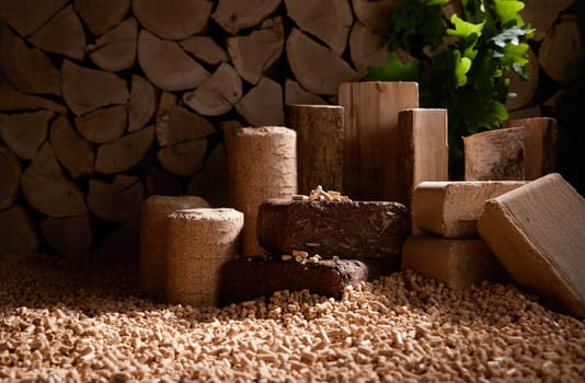 Heap of fuel pellets scattered near stack of chopped firewood and set of compressed biomass briquettes near oak leaves