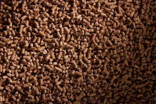 Top view full frame of pile of compressed wood pellets in daylight as abstract background