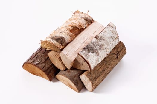 From above of cut firewood of different types and sizes stacked on white surface
