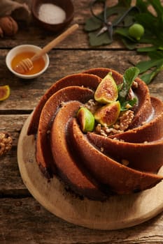 From above of sweet freshly bake cake made of figs with creative decoration served on cutting board in light kitchen