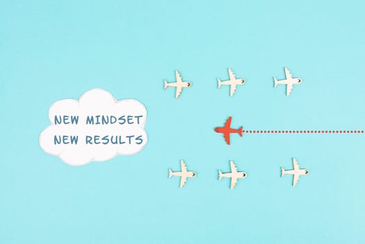 Red airplane is flying to the cloud with the words new mindset new results, changing lifestyle, coaching and improvement concept, positive thinking