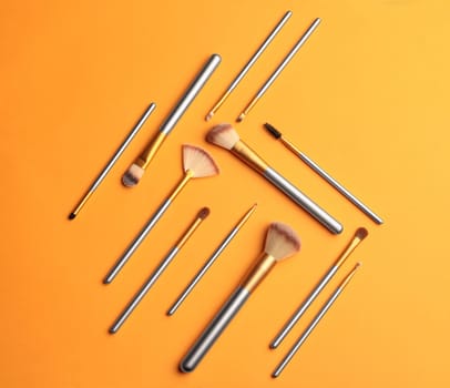 Makeup brushes over color background. Top view cosmetic image