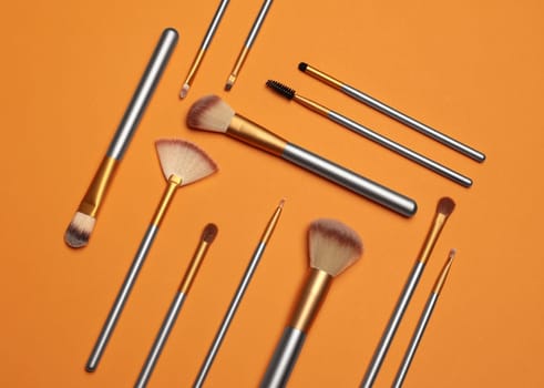 Makeup brushes over color background. Top view cosmetic image