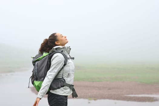 Side view portrait of a hiker breathing fresh air in the mountain a foggy day