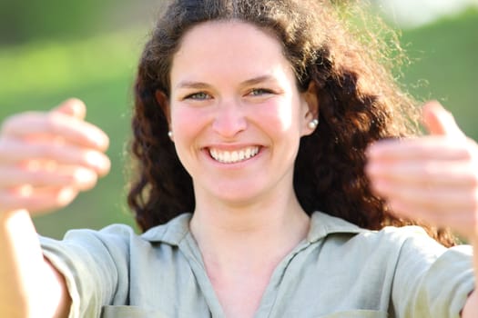 Front view portrait of a happy woman gesturing come here with both hands in a park