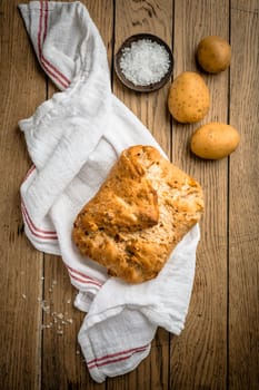Potato bread with spelt flour and roasted onions on wooden table