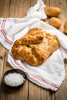 Potato bread with spelt flour and roasted onions on wooden table