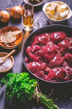 Raw chicken liver with cooking ingredients for liver pate, herbs and brandy
