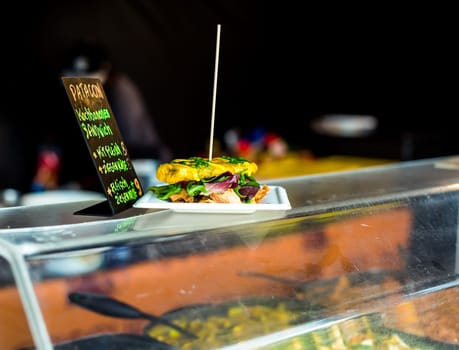 Patacon sandwich - traditional sandwich made from cooking bananas (plantains) with chicken meat and lettuce. Freshly prepared at food truck. African food.