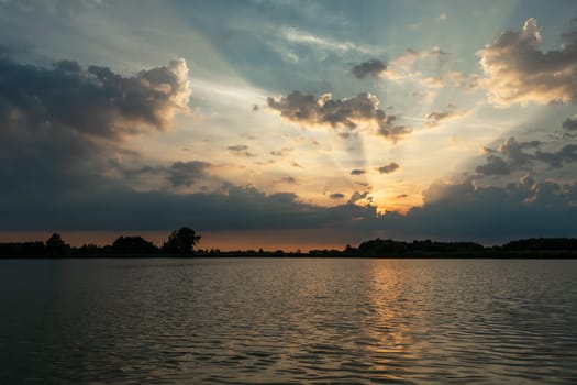 Sunset behind the clouds over the lake, Stankow, Lubelskie, Poland