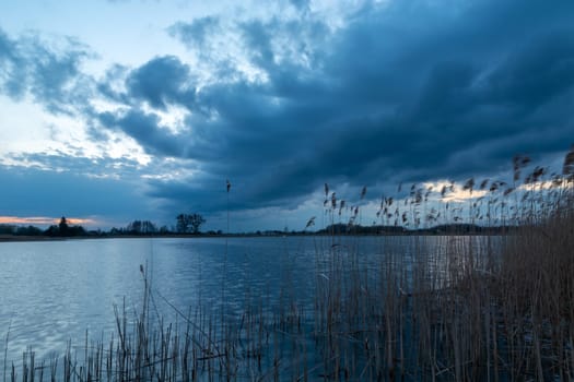 Dark cloud over the lake with reeds, Stankow, Lubelskie, Poland