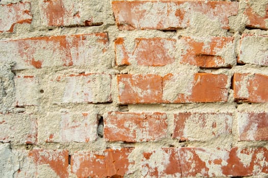 Wall of old red bricks and cement plaster, background