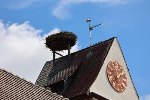 Church tower clock with stork's nest and stork on the church tower of Gundelfingen (district Breisgau-Hochschwarzwald)