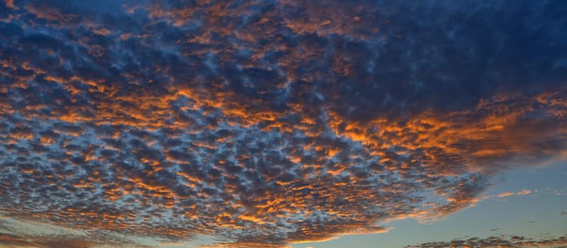 Scenic panoramic view of colorful sunset and cloudscape, dramatic panorama evening sky after sunset