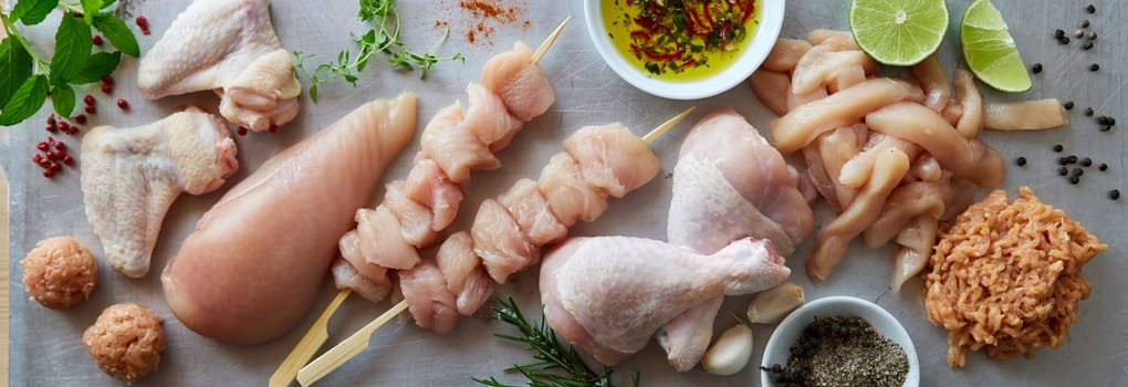Top view of uncooked chicken kebab near different types of meat placed on gray background in kitchen during cooking process