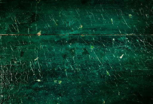 Background of wooden green worn out surface covered with abundance of scratches and various cracks