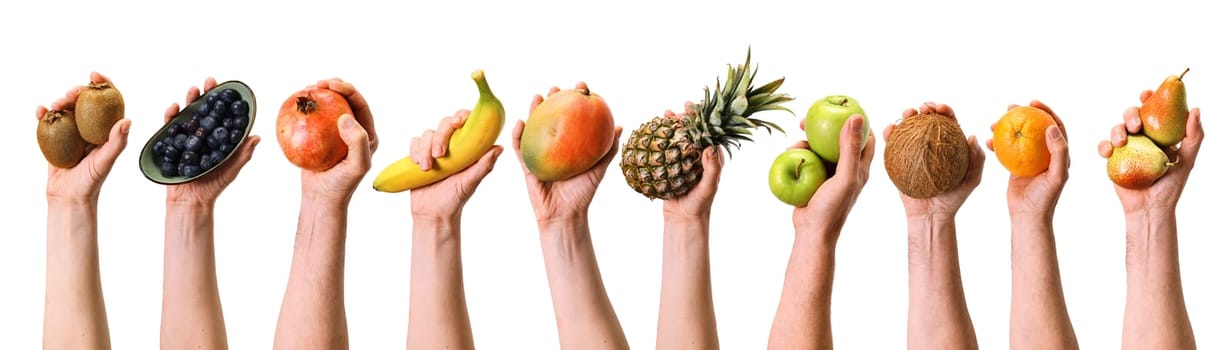 Hands of crop anonymous people holding various ripe fruits and berries on white background during harvesting season in light studio