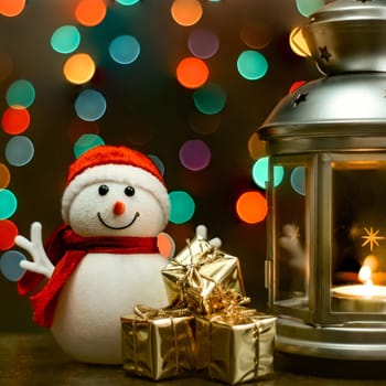 Christmas composition: A snowman, a lantern with candles, bright shiny boxes with gifts, blurred bokeh lights in the background.