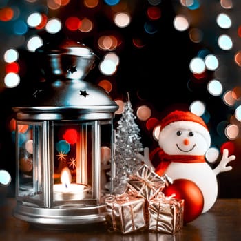 Christmas composition: A snowman, a lantern with candles, bright shiny boxes with gifts, blurred bokeh lights in the background.