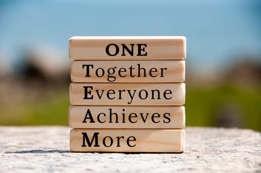 One Team text on wooden blocks with blurred nature background. Team work concept