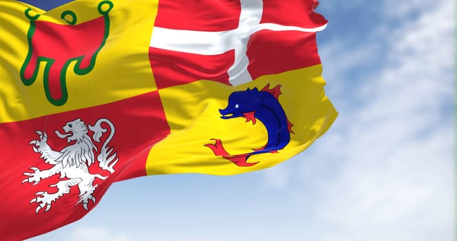 The flag of Auvergne-Rhone-Alps flying on a clear day. Auvergne-Rhone-Alpes is one of the regions of France.