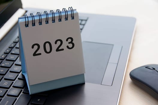 New year 2023 text on calendar desk on top of a laptop - New year concept