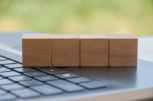 Blank wooden blocks on top of a laptop ready for new ideas. Copy space