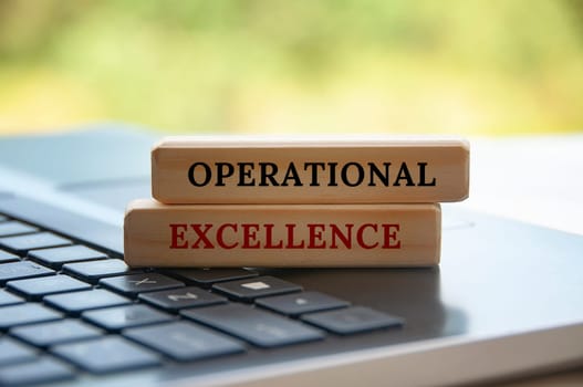 Operational excellence text on wooden blocks on top of a laptop. Business strategy concept