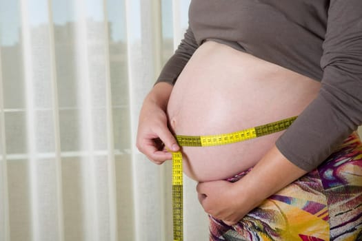Closeup of pregnant woman at home