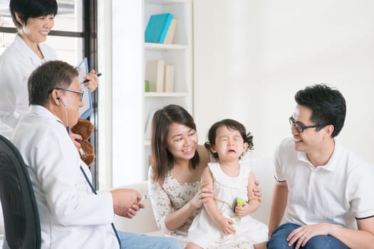 Child vaccination. Family doctor giving injection or vaccines to baby girl. Pediatrician and patient.