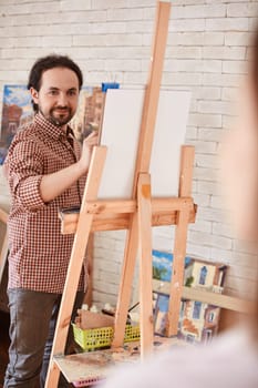 Young man drawing muse in studio