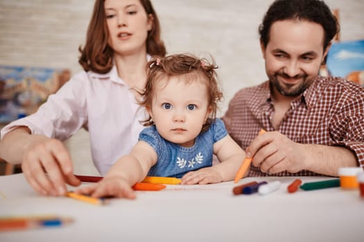 Small girl looking at camera on background of her parents