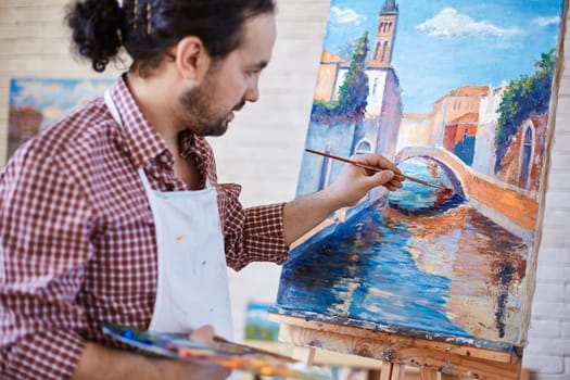 Young artist painting Italian landmark in studio