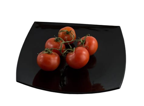 branch of tomatoes on a black plate