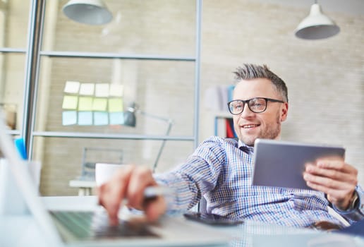 Mature businessman addicted to gadgets having break