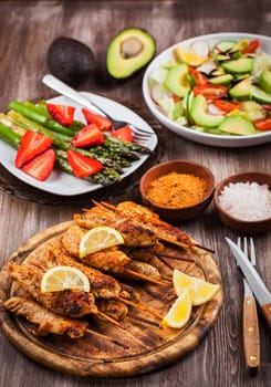 Grilled chicken skewers with green asparagus and avocado salad