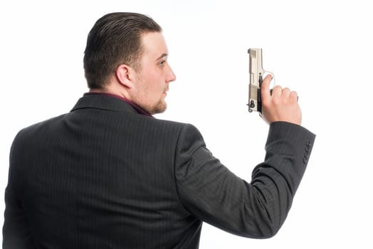 Young man in suit carries a gun
