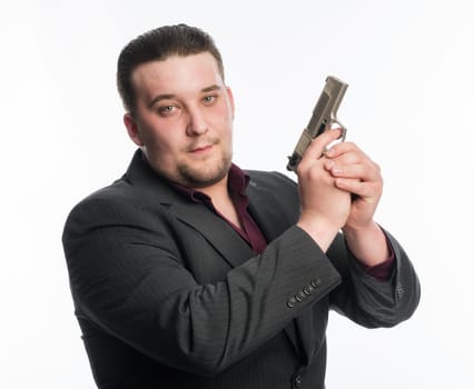 Young man in suit carries a gun