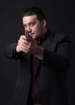 Young man in suit targets with gun